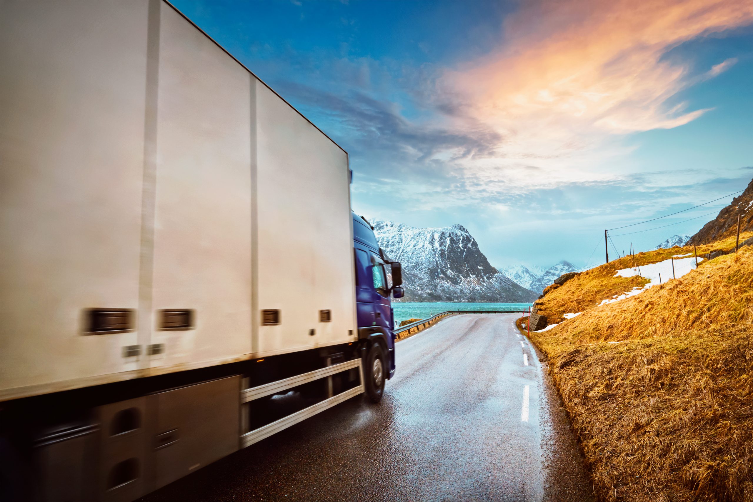 Truck driving down a long road